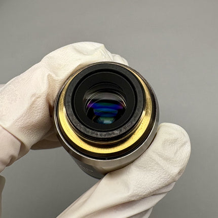 Olympus MPlanApo 20x0.60 ∞/0 RMS Objective lens with glove-covered hand holding it.