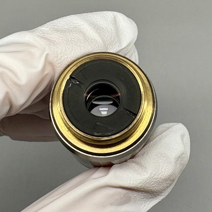 Olympus Microscope UMPlanFl 20x0.46 ∞/0 RMS Objective lens held with gloved hands.