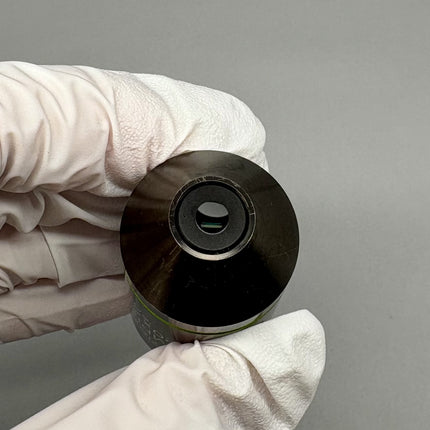 Olympus Microscope UMPlanFl 20x0.46 ∞/0 RMS Objective viewed from the front, held with gloved hand.