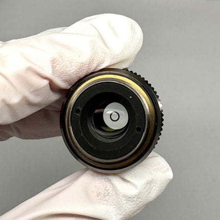 Olympus LUCPlanFL N 20x0.45 Ph1 ∞/0-2/FN22 UIS2 Objective held by gloved hand, showcasing its detailed design.