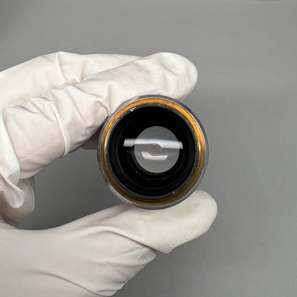 Close-up of Nikon S Fluor 10x0.50 DIC N1 ∞/0.17 WD 1.2 Microscope Objective held in a gloved hand