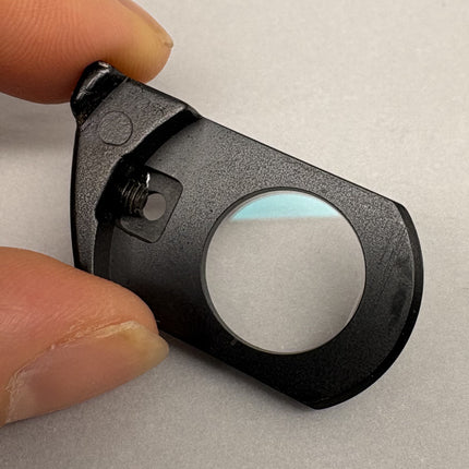 Nikon Plan Apo 100 oil DIC Nomarski Prism Slider f/ Plan Apo 100x oil Objective in hand, showcasing clear optical glass.