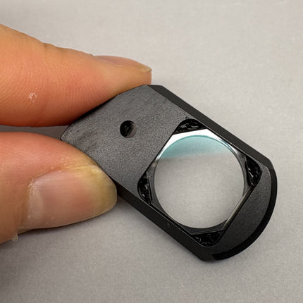 Nikon Plan Apo 100 oil DIC Nomarski Prism Slider f/ Plan Apo 100x oil Objective held in hand with sleek black casing.