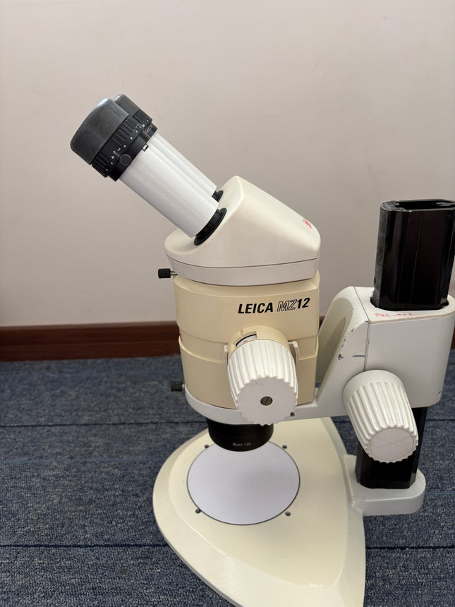 Leica MZ12 Stereo Microscope W/ 10X21B Eyepieces and PLAN 1.0x Objective showing eyepiece and zoom body in good condition.