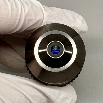 Olympus LCPlanFl 100x/0.80 LCD ∞/0.6-1.2 Microscope Objective held in gloved hand, showcasing optical lens design.