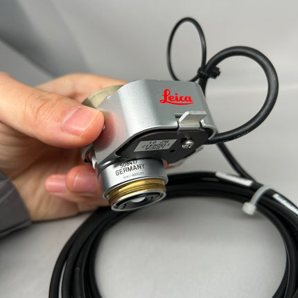 Leica Objective HC PL APO 93x/1,30 GLYC motCORR STED WHITE 506417 held in hand with cables visible.