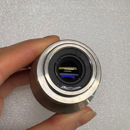 Nikon TV Lens C-0.35x C-Mount Camera/Photo Adapter held in hand to showcase optical features