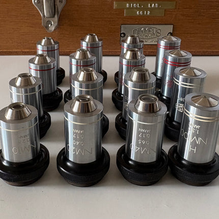 Rare New Old Stock Olympus Phase Contrast NH NM PL PLL Objectives RMS displayed in a collection.