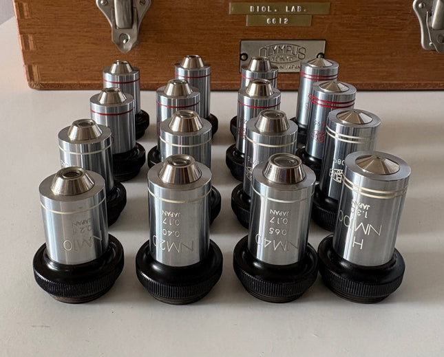 Rare New Old Stock Olympus Phase Contrast NH NM PL PLL Objectives RMS displayed in a collection.