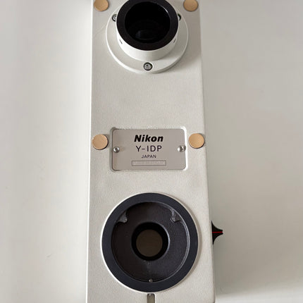 Nikon Y-IDP Dual Microscope Camera Port showing the top view with multiple ports and branding.