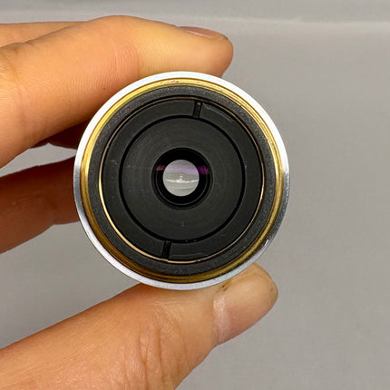Hand holding Nikon L Plan EPI CR 50x0.70 ∞/0-1.2 EPI OFN25 MUE35500 Objective lens showing the aperture.