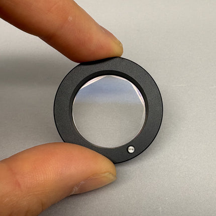 Olympus Microscope U-DIC60 DIC Nomarski Prism  being held with fingers, demonstrating its optical design and precision.