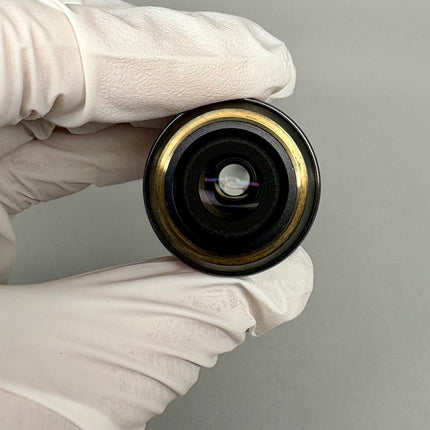 Olympus PlanApo N 60x1.40 Oil SC ∞/0.17 UIS2 A-Line Objective lens viewed from the front in a gloved hand.
